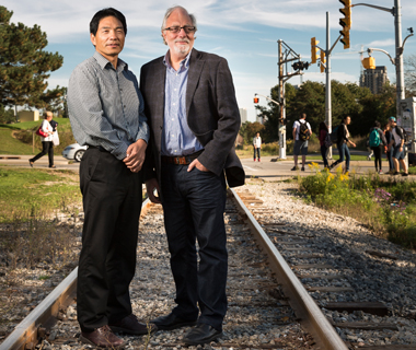 Liping Fu and Frank Saccomanno stand at a railway crossing